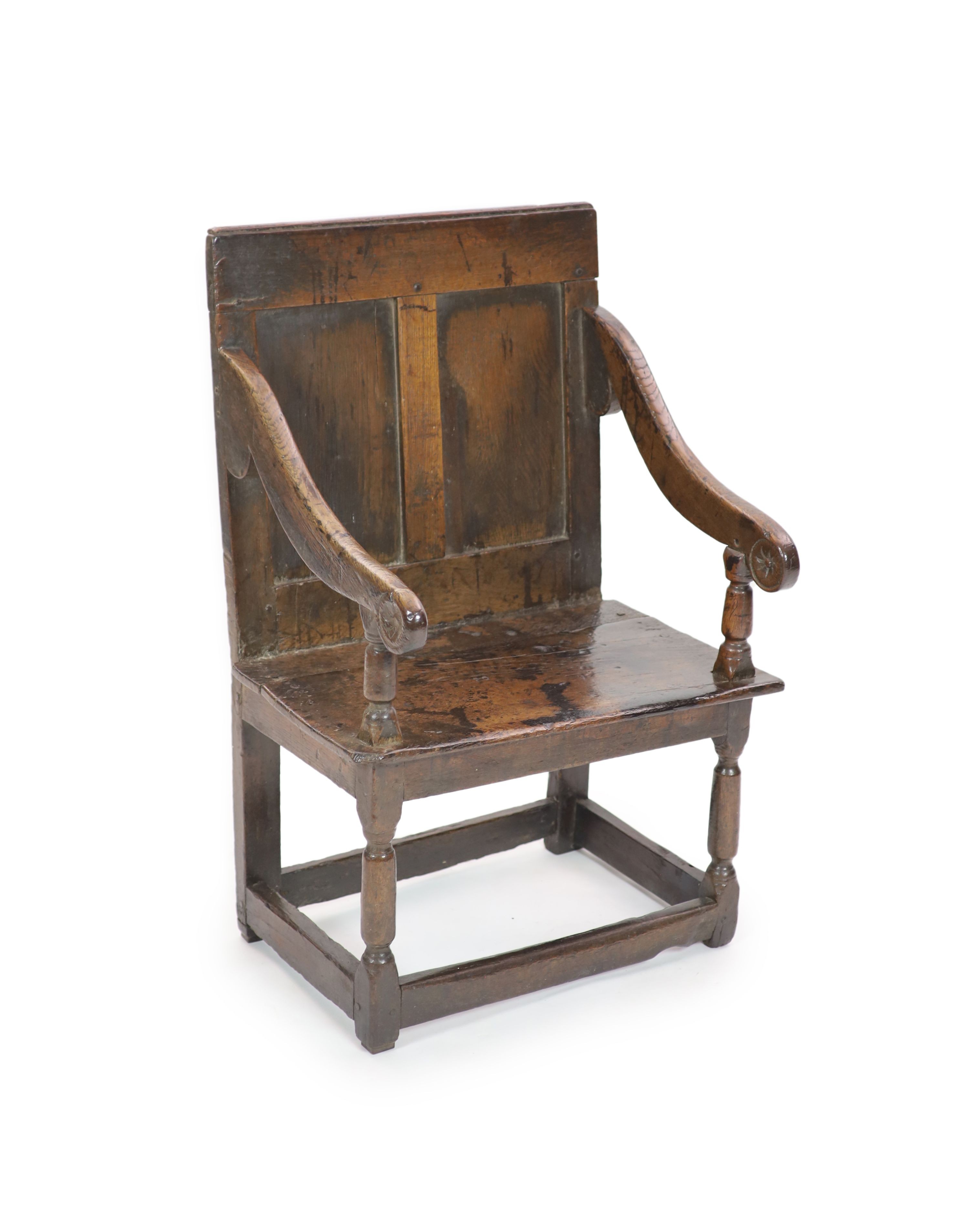 A 17th century panelled oak open armchair, the seat initialled 'PO' H 97cm. W 66cm. D 52cm.